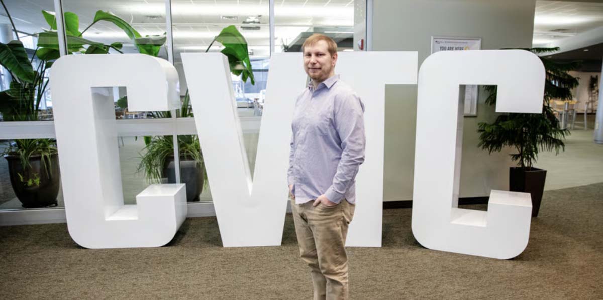 A man standing in front of a sign for Chippewa Valley Technical College.