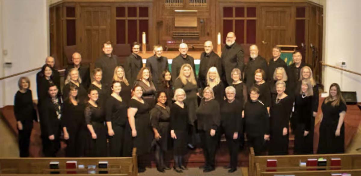 A choir of men and women wearing black robes.