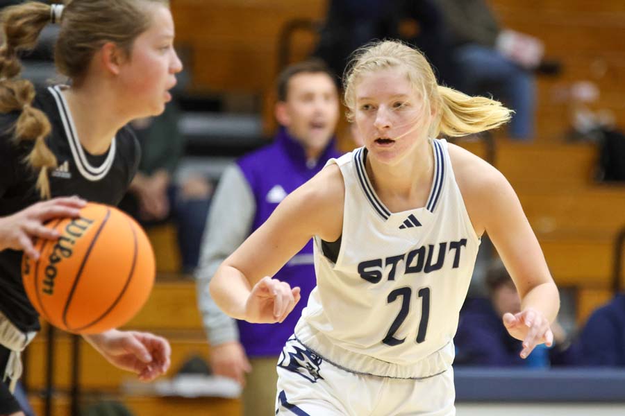 A women's basketball player looks to drive around her opponent.