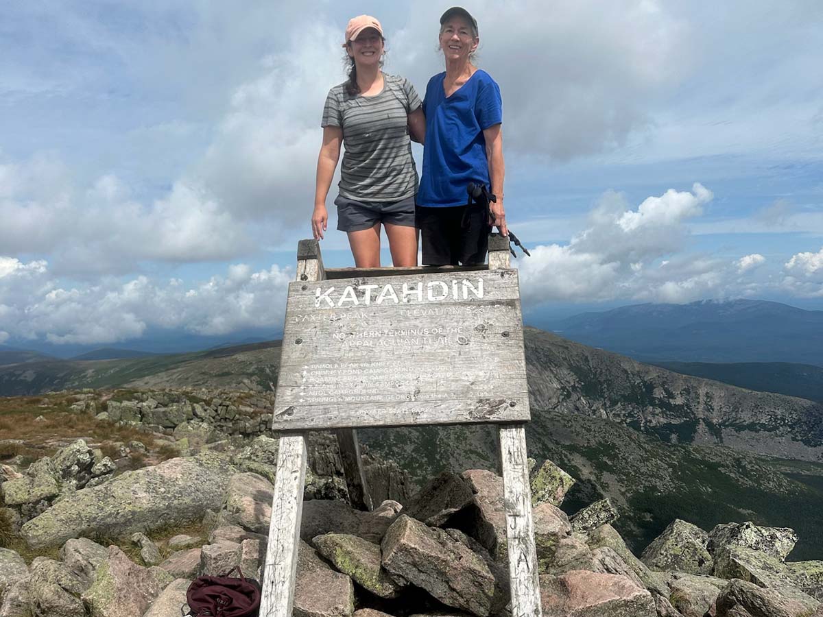 Two women standing in front a sign on the Appalachian Trail