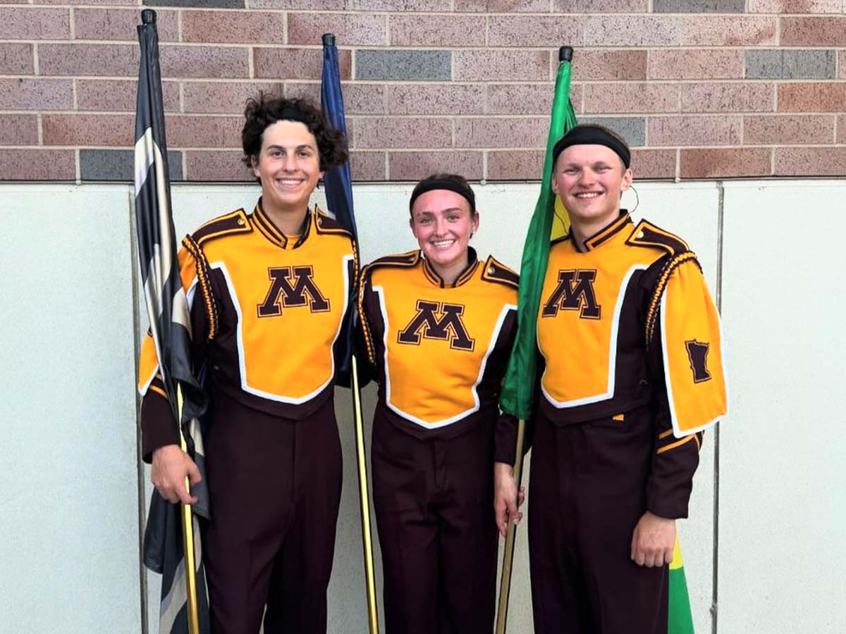 Three members of the University of Minnesota Marching Band in their gold and maroon uniforms