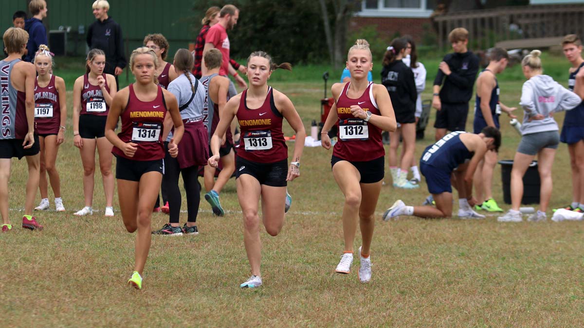 three Menomonie high school cross country team members warm up with a short run