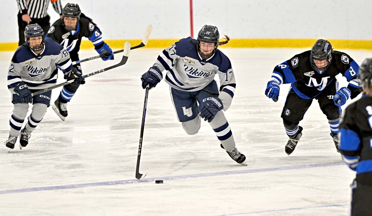 Ashley Slupe, a member of the Lawrence University women's hockey team, moves the puck down the rink.