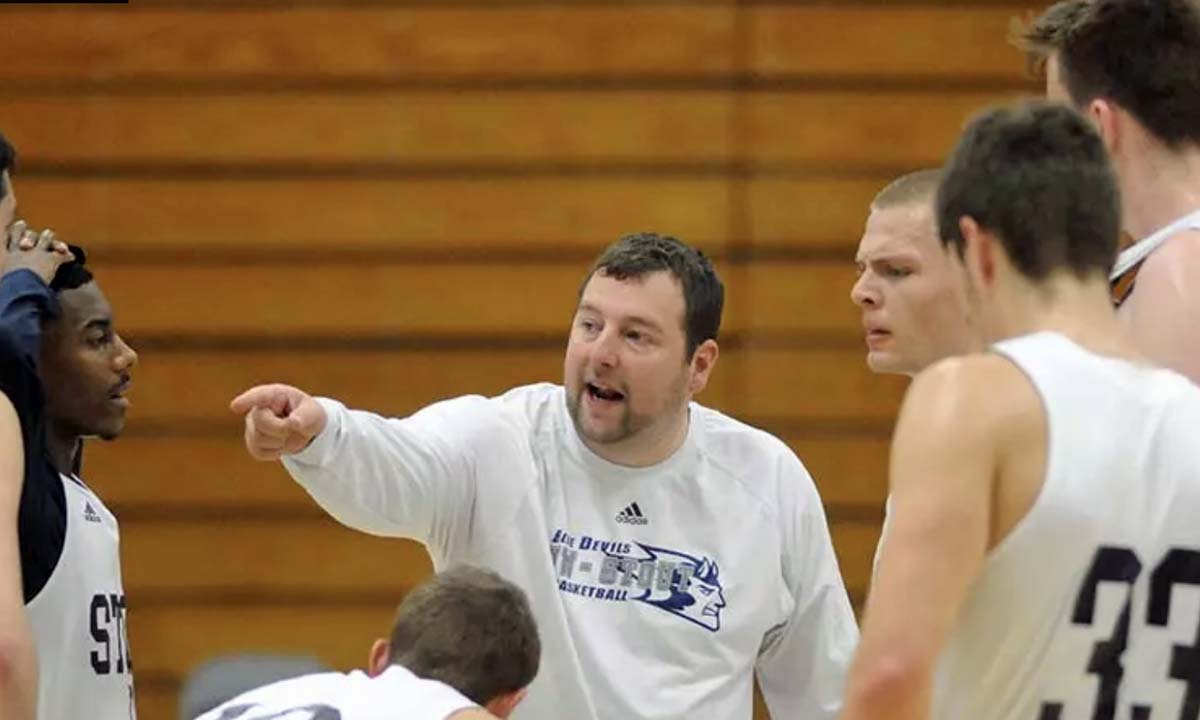 A men's basketball coach describes a drill to his player during a practice sesson.
