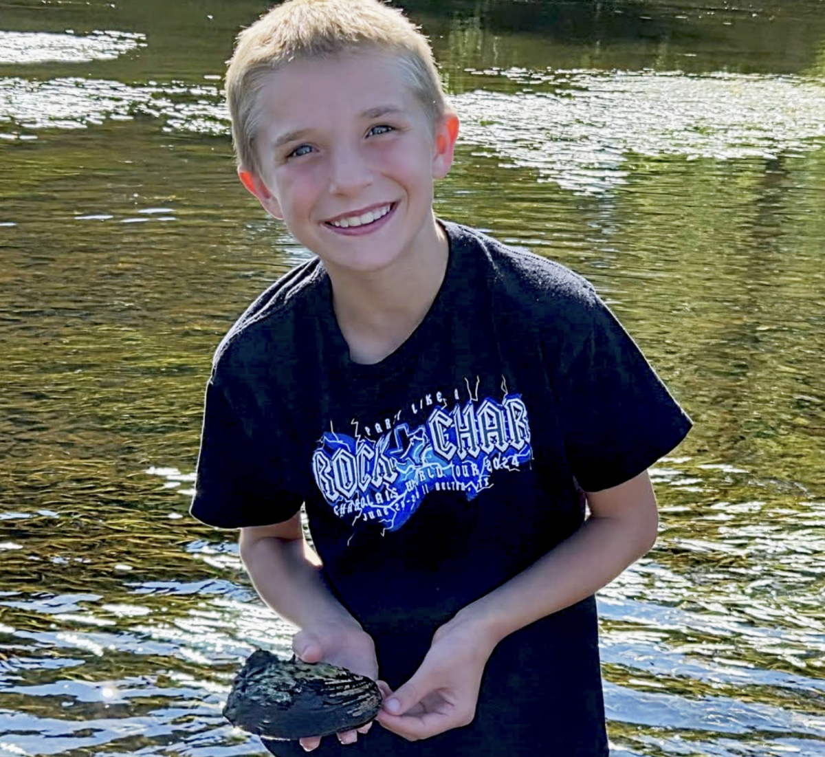 4-H member Brody Wantoch relocates an endangered freshwater mussel to safety in the waters of the St. Croix River. Photo: Zachary Rozmiarek