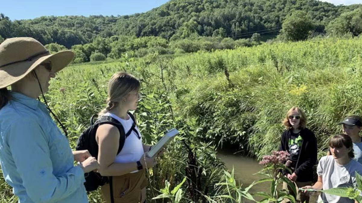 Student in an enviroment class working in a small creek.